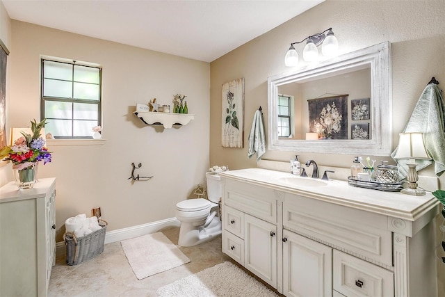 bathroom featuring toilet, vanity, tile patterned floors, and baseboards