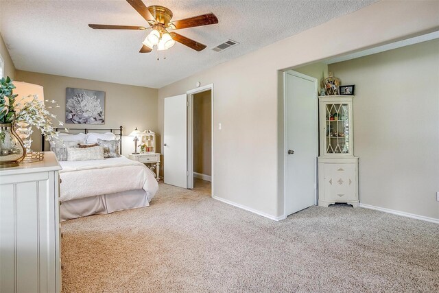 carpeted bedroom with a textured ceiling and ceiling fan