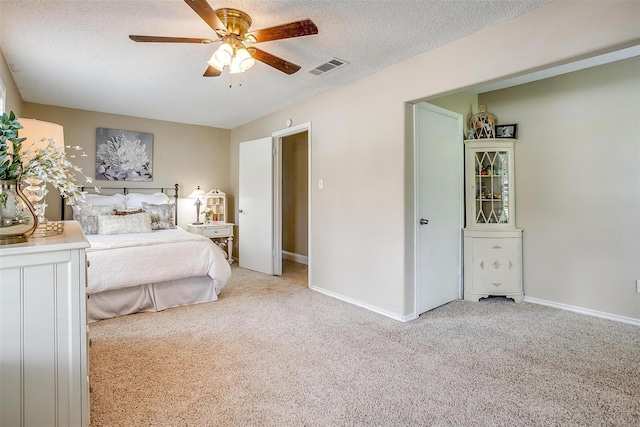 bedroom featuring baseboards, visible vents, carpet floors, and a textured ceiling