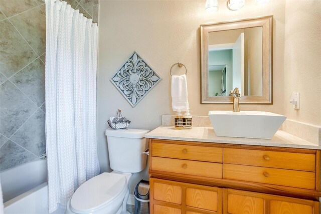 full bathroom featuring vanity, shower / bath combo, and toilet