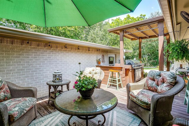 deck featuring a pergola, outdoor dry bar, and area for grilling