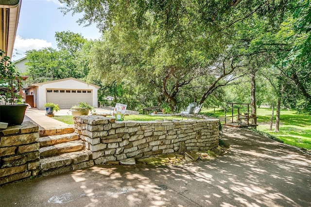 view of patio with a garage and an outbuilding