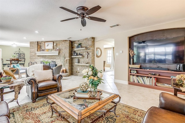living area with visible vents, arched walkways, ceiling fan, and tile patterned flooring