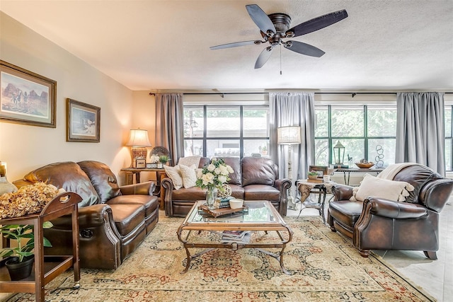 tiled living room with a textured ceiling, ceiling fan, and a wealth of natural light