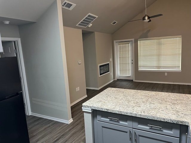 kitchen featuring gray cabinets, ceiling fan, black fridge, dark hardwood / wood-style floors, and lofted ceiling