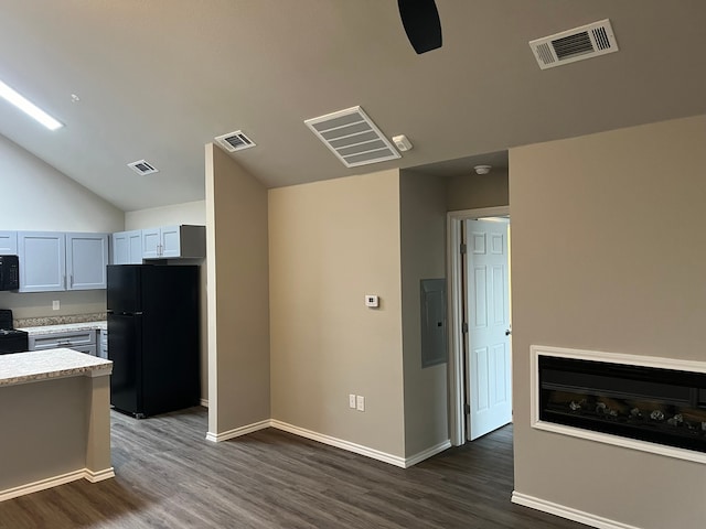 kitchen with dark wood-type flooring, electric panel, gray cabinets, black appliances, and vaulted ceiling