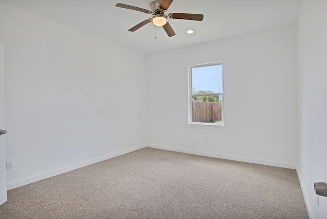 carpeted spare room with ceiling fan