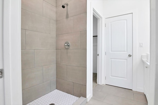 bathroom with tiled shower and tile patterned flooring