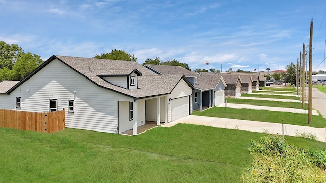 back of property featuring a garage and a lawn