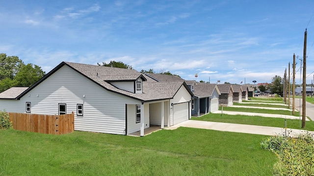 rear view of property with a garage and a yard