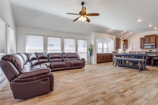 living room featuring ceiling fan, light hardwood / wood-style flooring, and lofted ceiling