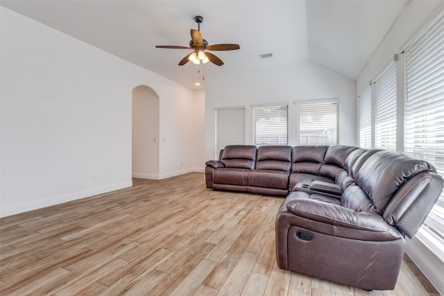 living room with ceiling fan, light hardwood / wood-style floors, vaulted ceiling, and a wealth of natural light