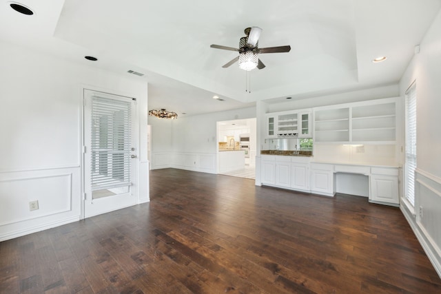 unfurnished living room with a raised ceiling, sink, ceiling fan, and dark hardwood / wood-style floors