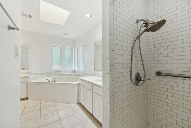 bathroom with a skylight, tile patterned flooring, separate shower and tub, and vanity