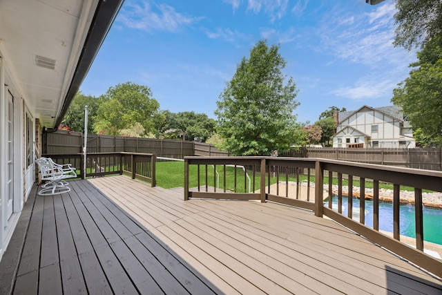 wooden terrace featuring a yard and a fenced in pool