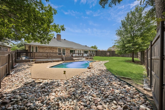 view of pool with a patio, a lawn, and a wooden deck