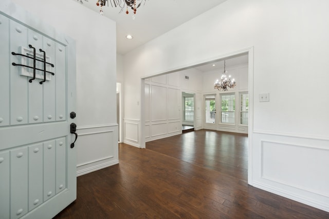 foyer entrance with a chandelier and dark wood-type flooring