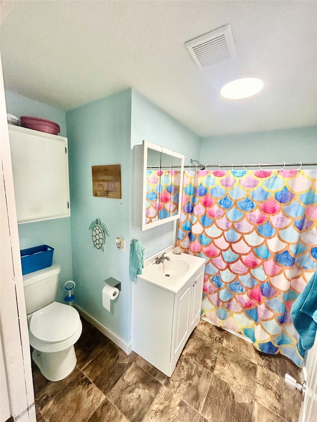 bathroom featuring vanity, tile patterned flooring, and toilet