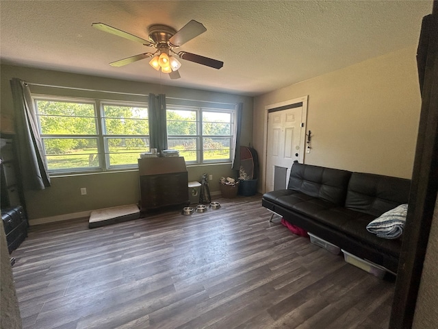 living room featuring a textured ceiling, hardwood / wood-style flooring, and ceiling fan