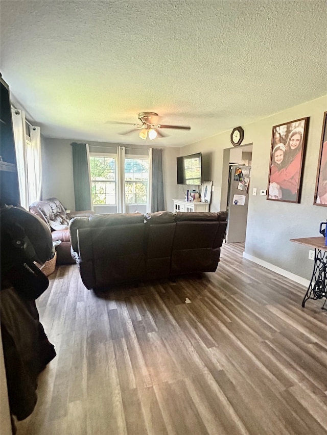 living room with a textured ceiling, ceiling fan, and hardwood / wood-style floors