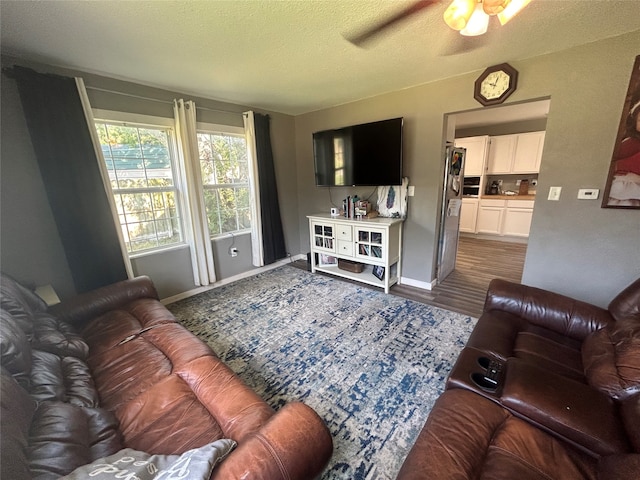 living room featuring a textured ceiling, hardwood / wood-style flooring, and ceiling fan