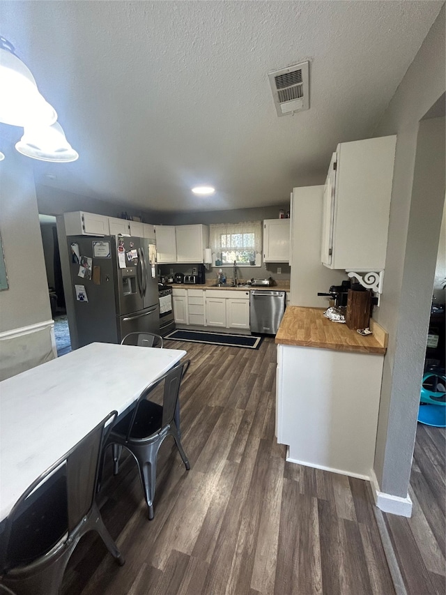 kitchen featuring a textured ceiling, dishwasher, dark hardwood / wood-style floors, and refrigerator with ice dispenser