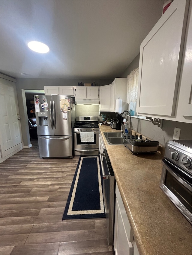 kitchen featuring appliances with stainless steel finishes, hardwood / wood-style flooring, and white cabinetry