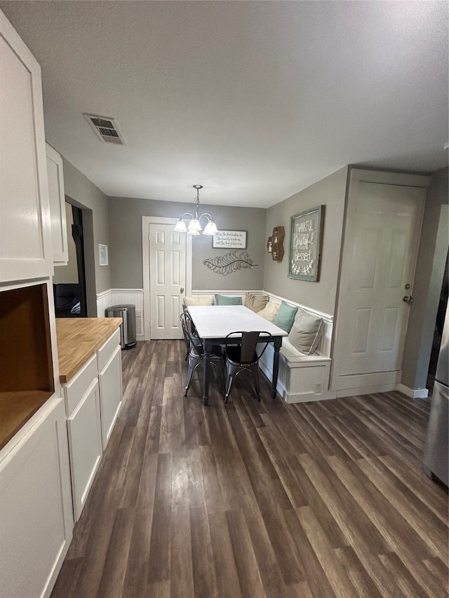 dining area featuring dark hardwood / wood-style floors and a chandelier