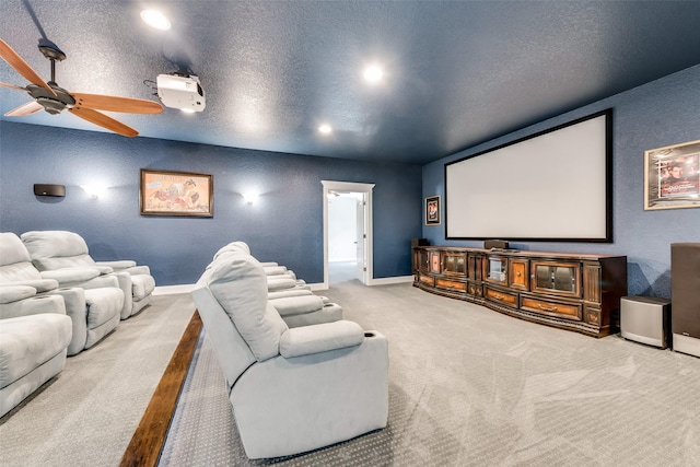 carpeted home theater with ceiling fan and a textured ceiling