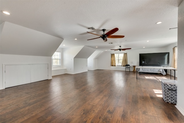 additional living space with ceiling fan, dark wood-type flooring, a wealth of natural light, and lofted ceiling