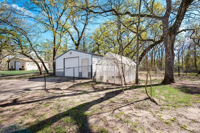 view of yard with a garage and an outbuilding