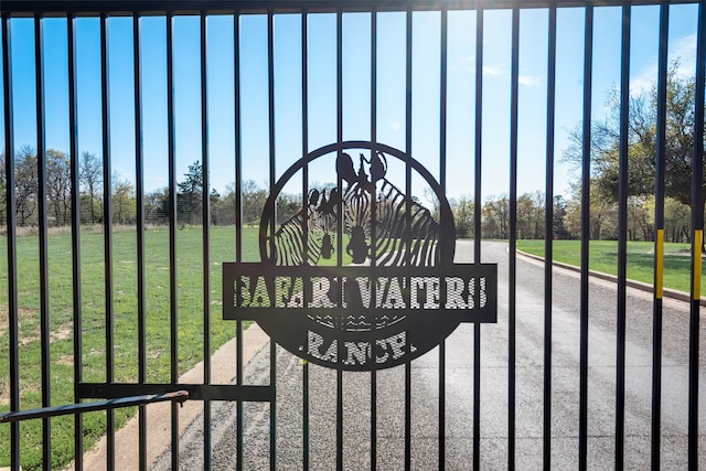 view of gate with a lawn