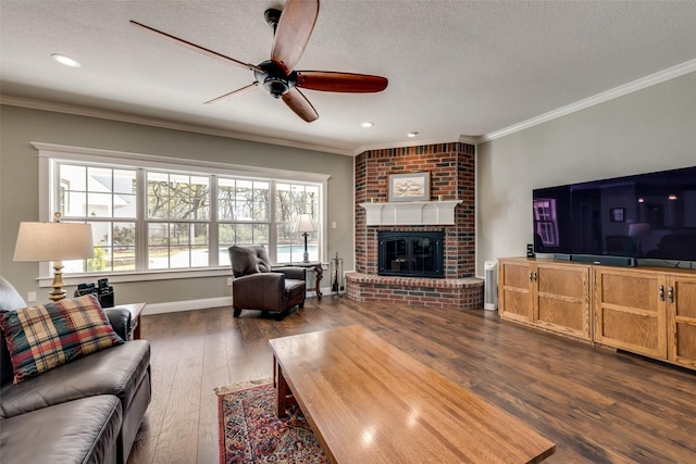 living room featuring a brick fireplace, a textured ceiling, dark hardwood / wood-style flooring, and ornamental molding