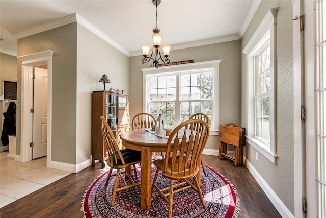 dining area featuring wood-type flooring, a chandelier, and ornamental molding