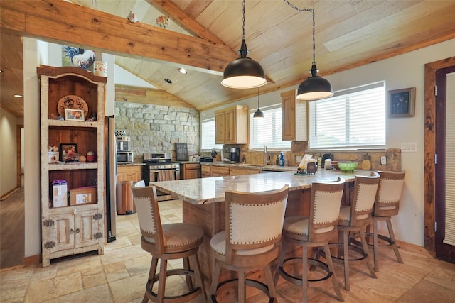 kitchen featuring appliances with stainless steel finishes, light tile patterned flooring, a breakfast bar area, and wood ceiling