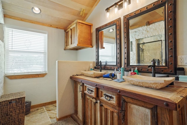 bathroom with vaulted ceiling, double vanity, and tile patterned flooring