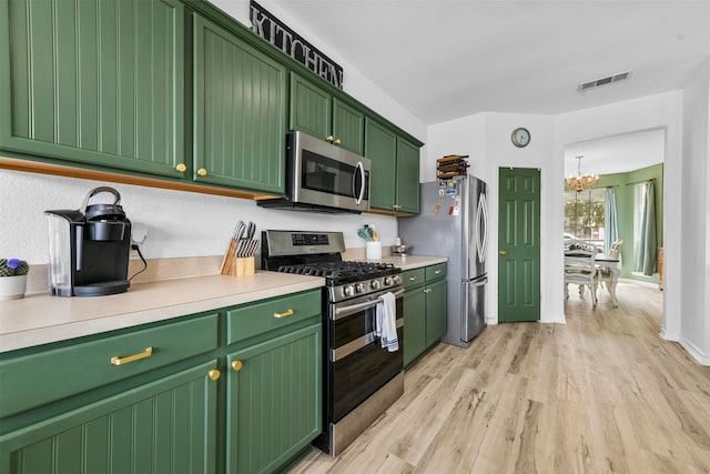 kitchen with light wood-type flooring, green cabinetry, an inviting chandelier, and stainless steel appliances