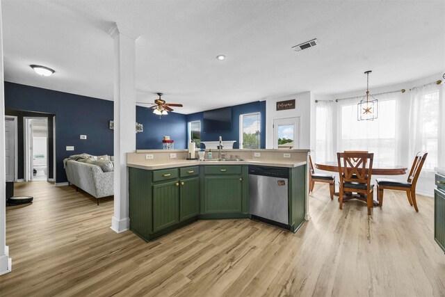 kitchen featuring dishwasher, light hardwood / wood-style floors, green cabinets, a center island with sink, and decorative light fixtures