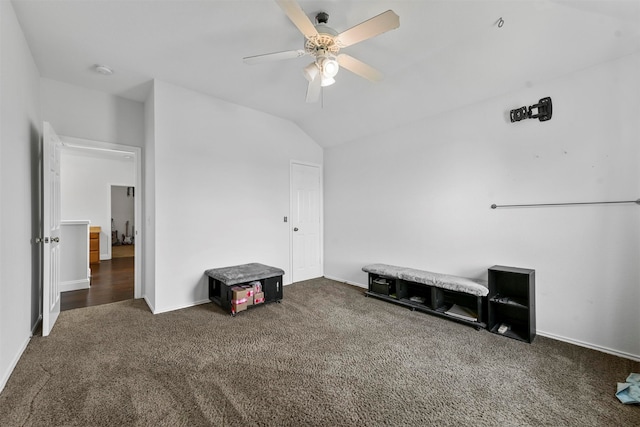 unfurnished bedroom with dark colored carpet, lofted ceiling, and ceiling fan