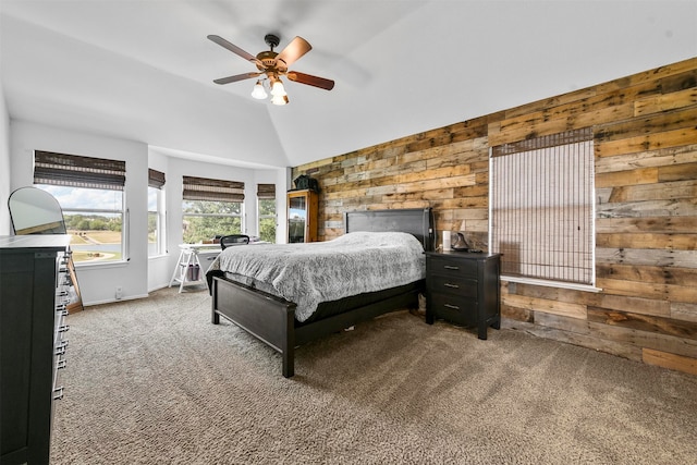 bedroom featuring wooden walls, carpet, ceiling fan, and vaulted ceiling