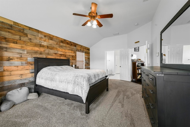 carpeted bedroom featuring lofted ceiling, wood walls, and ceiling fan