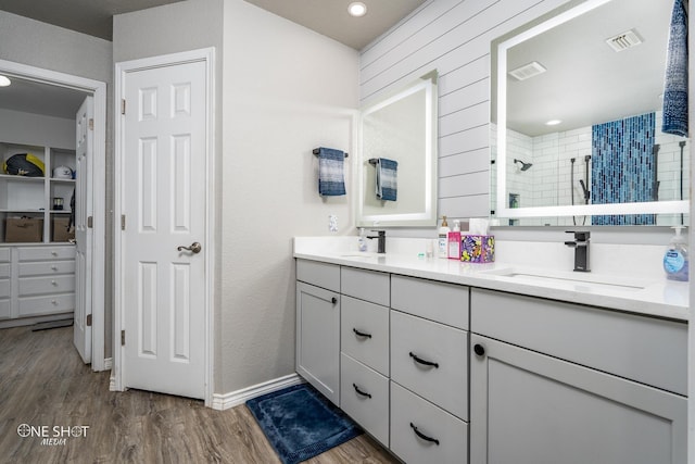 bathroom featuring a tile shower, hardwood / wood-style flooring, and vanity