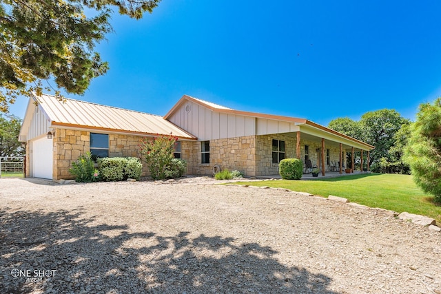 view of front of home with a garage, a front lawn, and covered porch