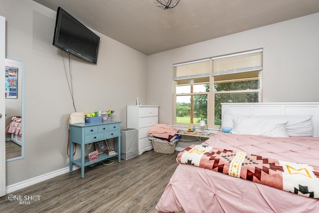 bedroom featuring a textured ceiling and dark hardwood / wood-style flooring