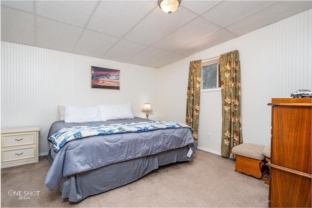 bedroom featuring light colored carpet and a drop ceiling