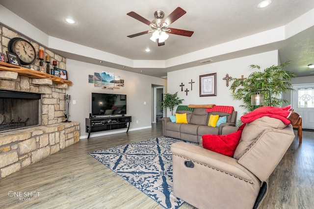 living room with ceiling fan, a fireplace, and wood-type flooring