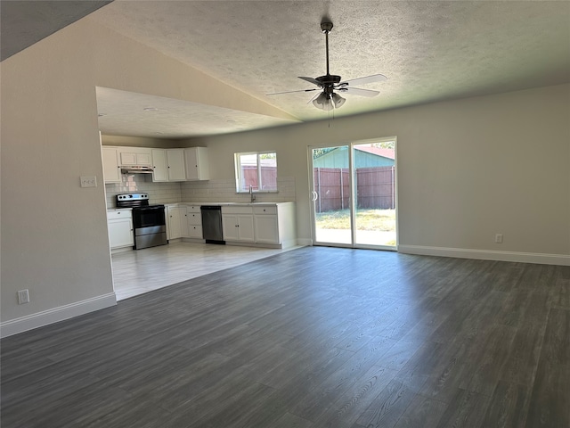 unfurnished living room featuring a textured ceiling, lofted ceiling, ceiling fan, sink, and hardwood / wood-style floors