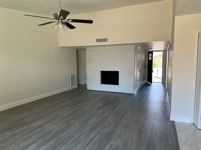 unfurnished living room with a textured ceiling, ceiling fan, a brick fireplace, high vaulted ceiling, and dark hardwood / wood-style flooring