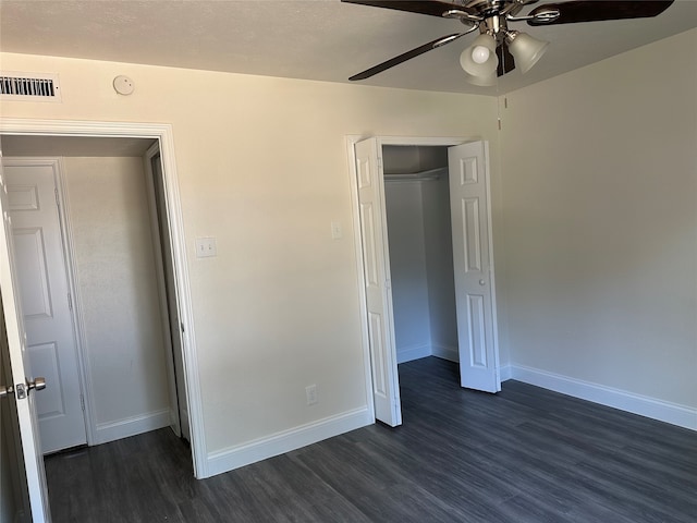 unfurnished bedroom featuring ceiling fan, dark hardwood / wood-style floors, and a closet