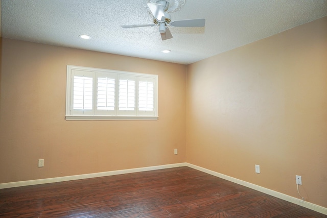 spare room featuring ceiling fan, dark wood-type flooring, and a textured ceiling